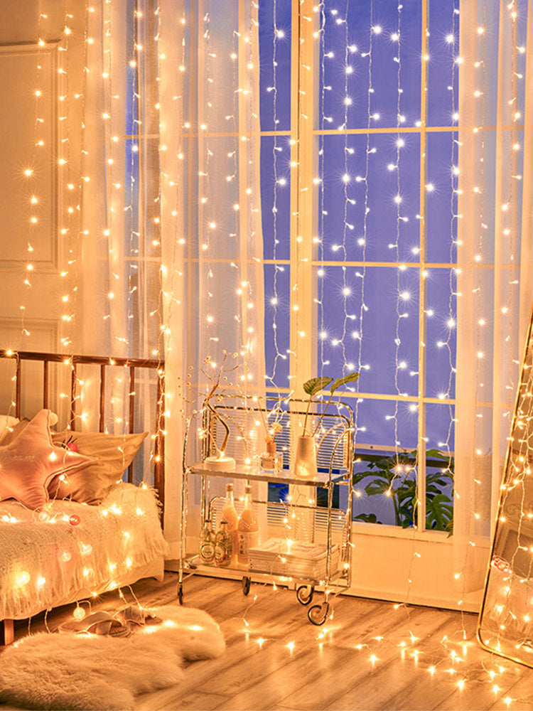 LED curtain string lights glowing across a bedroom window